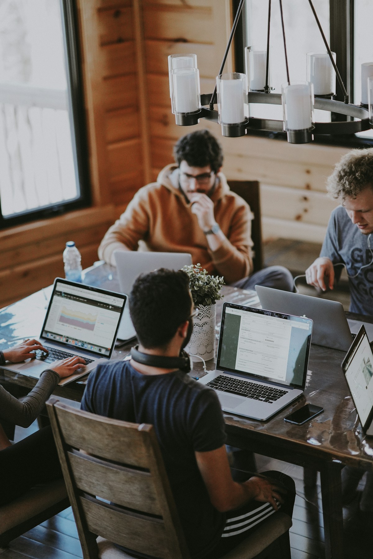 Entrepreneurs collaborating around a table with their laptops
